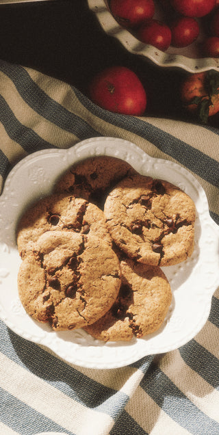 Cookies on a white plate with apples in the background